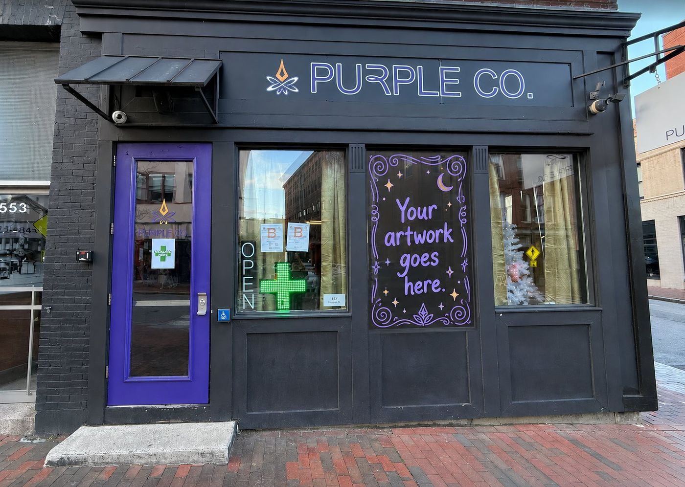 A Purple Co. storefront lit purple at night